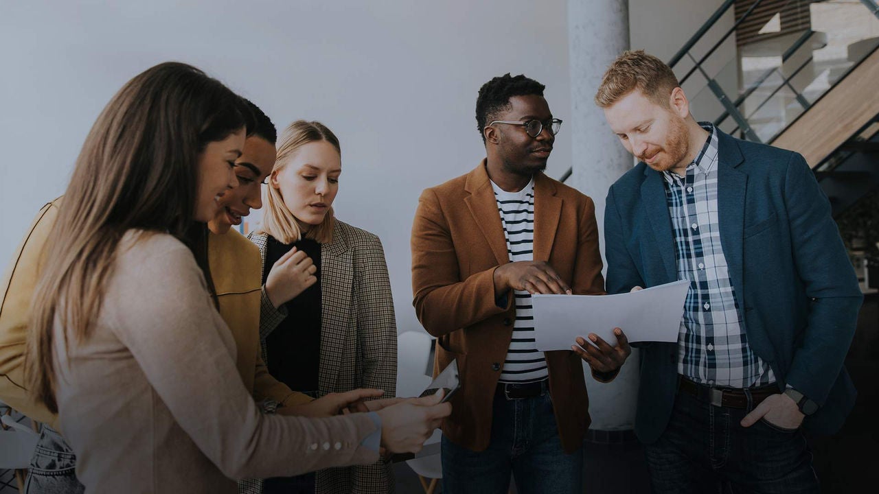 A group of people standing around a table