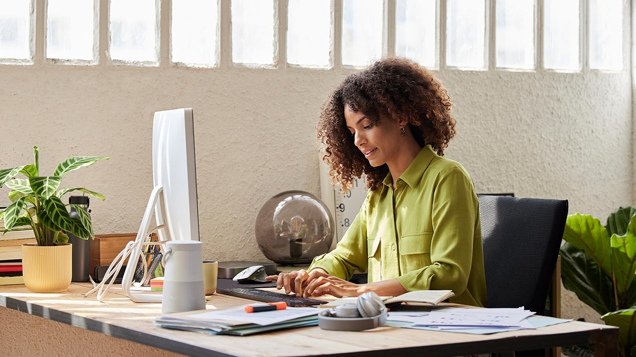 Woman in a green blouse working in an office.