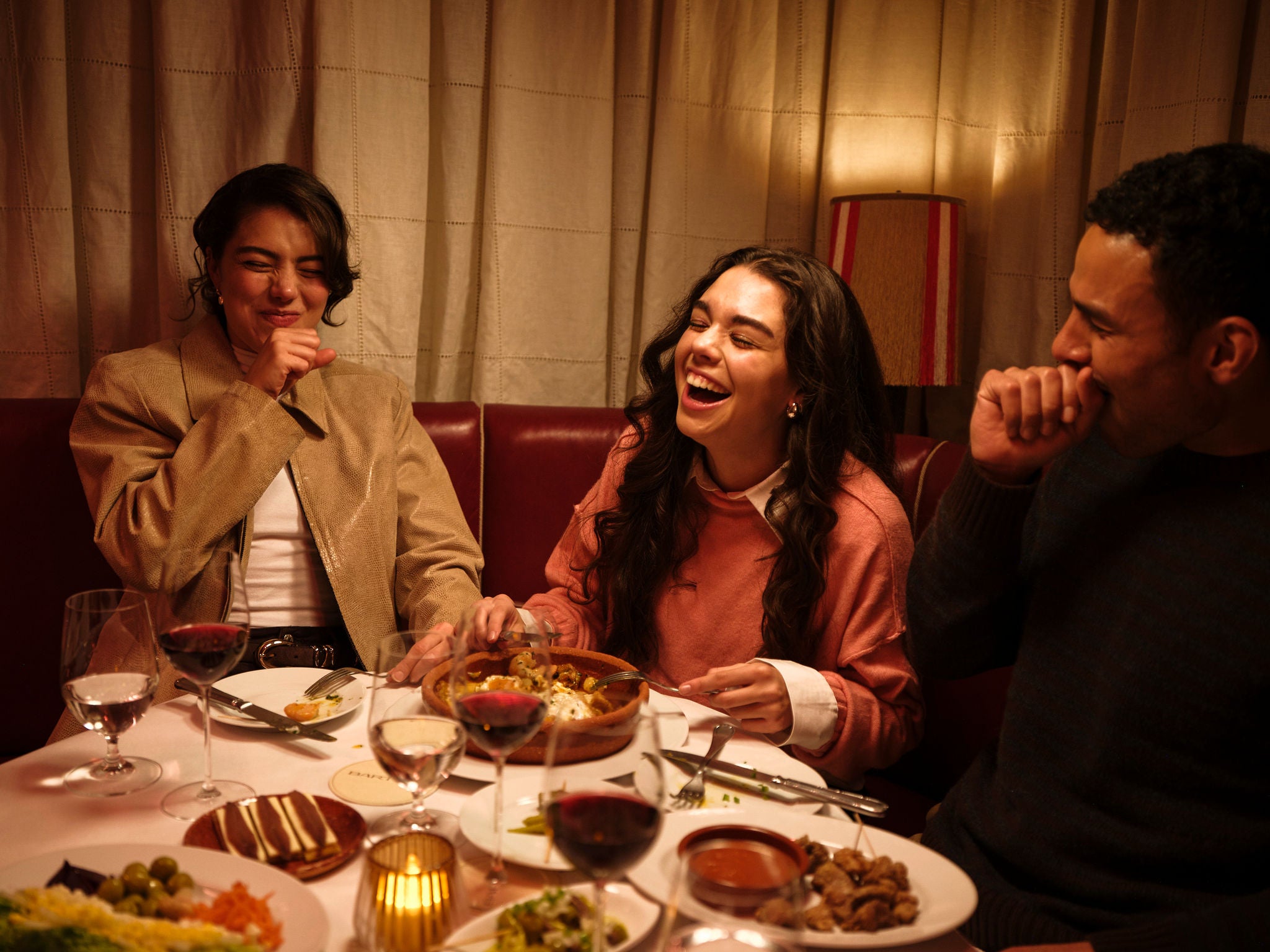Friends around table enjoying a meal.