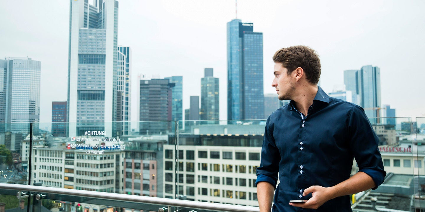 Man using his phone overlooking a city