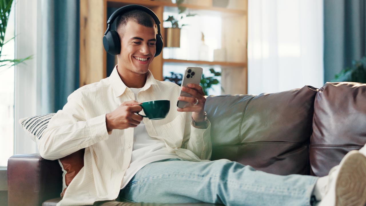Man using phone on couch while relaxing.