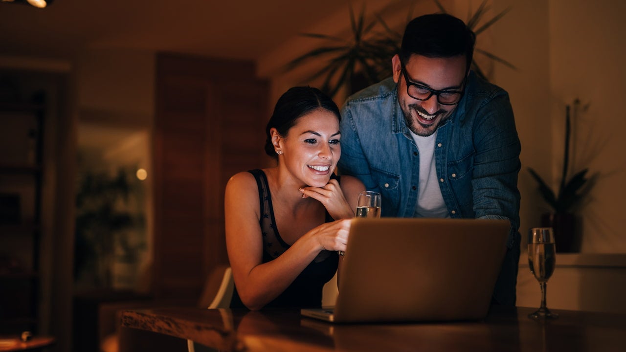 happy couple smiling at laptop screen