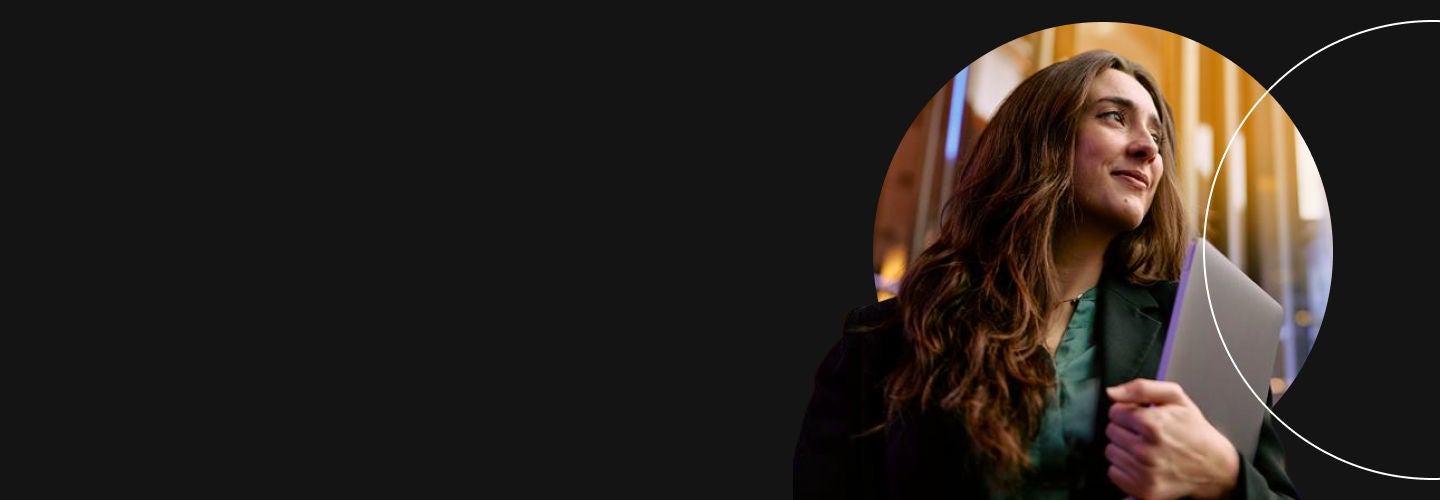 Woman holding laptop looking into the distance