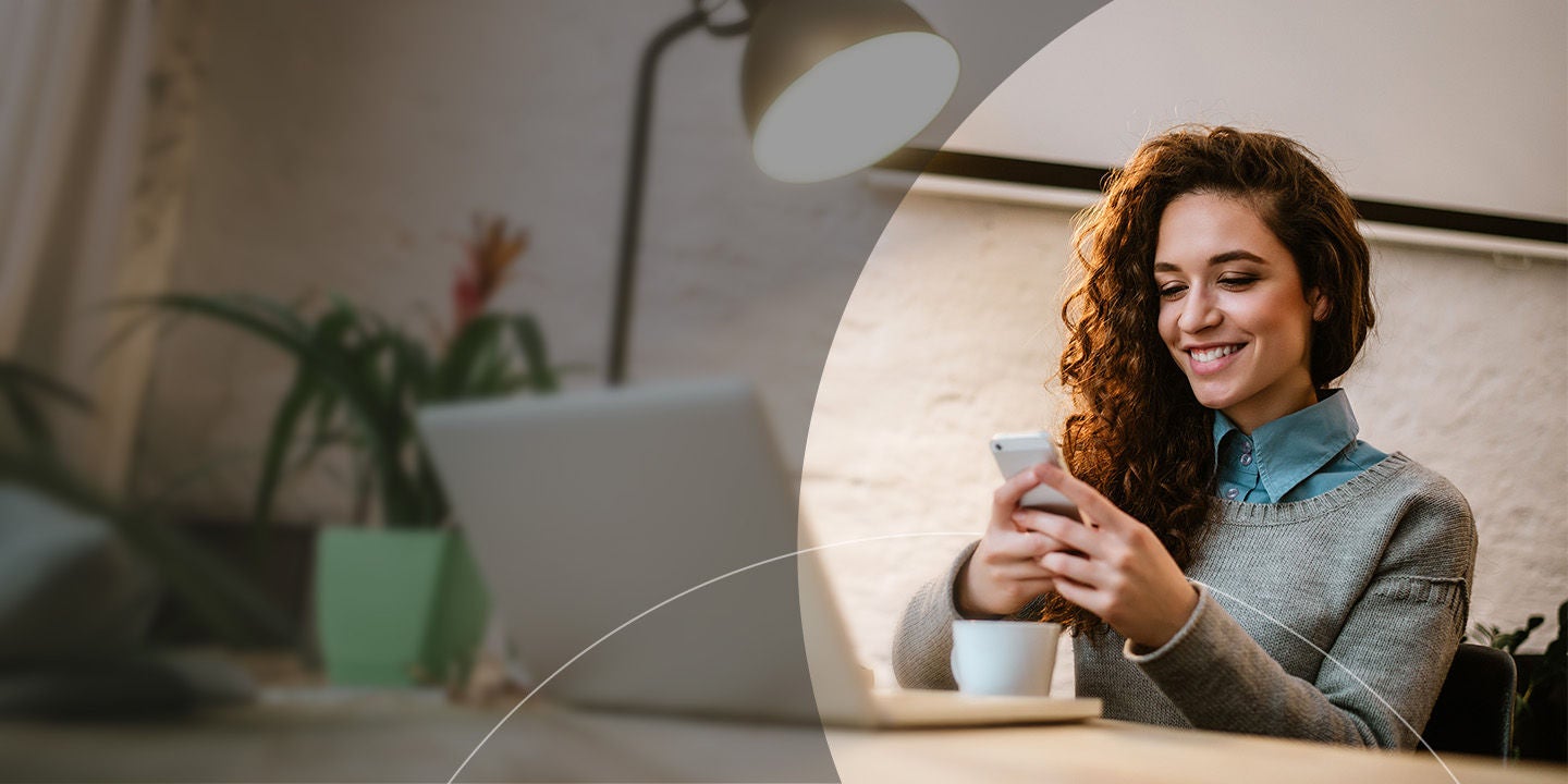 Girl looking into her phone over a coffee.