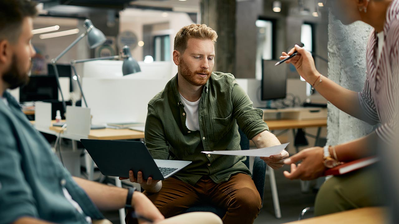 Three colleagues strategizing at work.