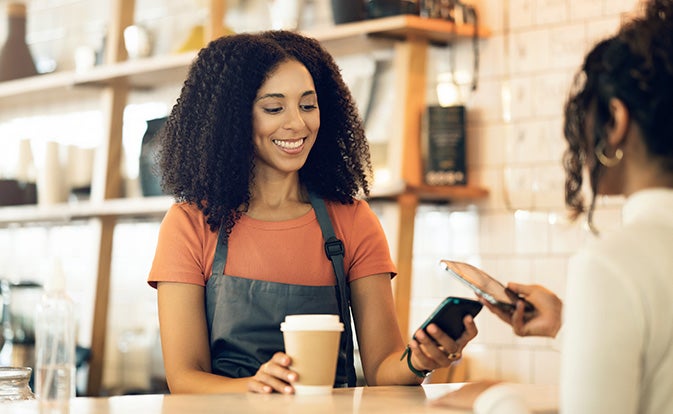 Small business owner using Tap on Phone to accept payment from customer. 