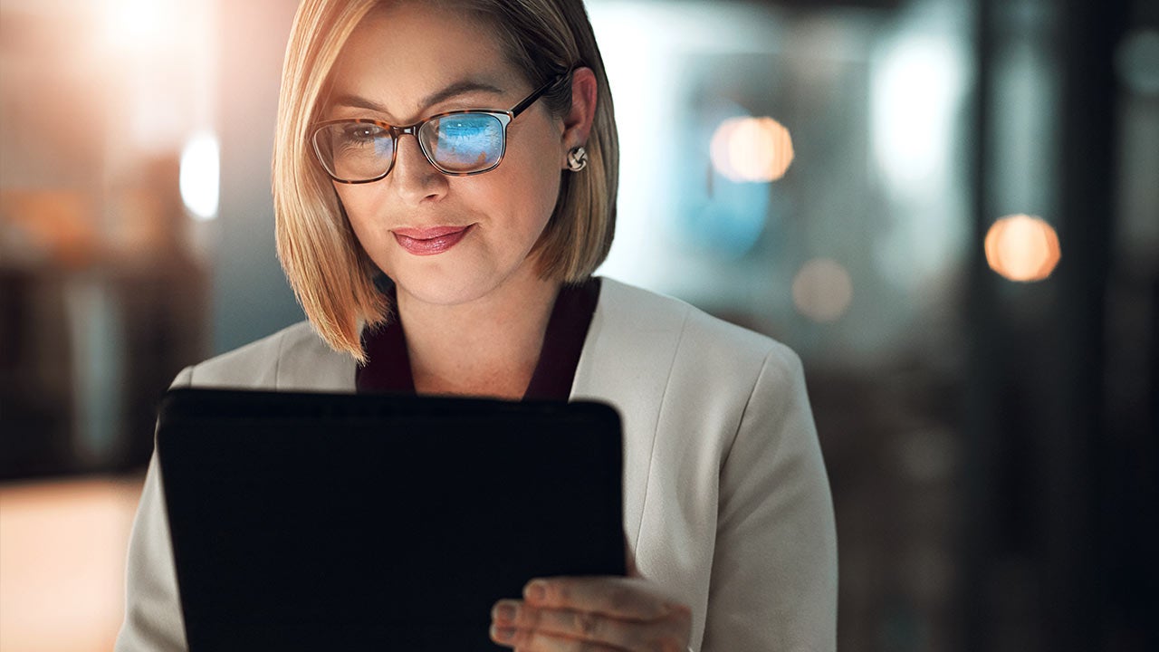 Business woman focusing on tablet.