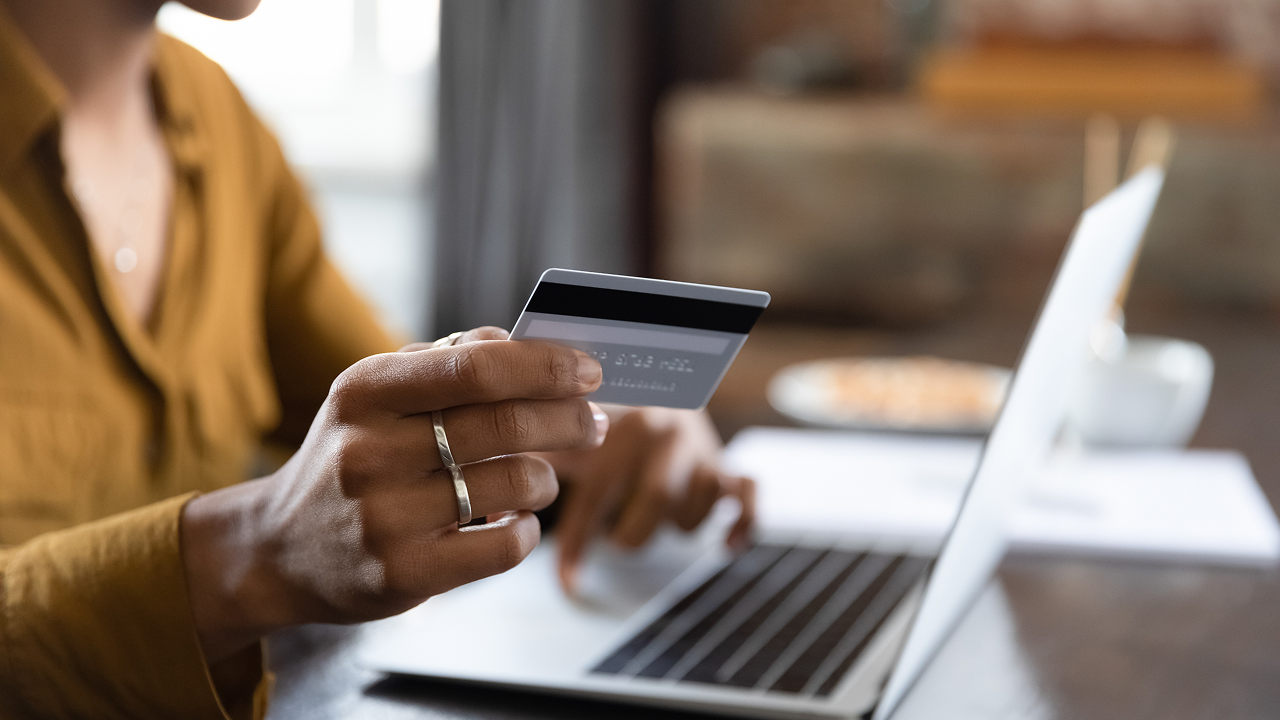 Woman holding credit card on laptop