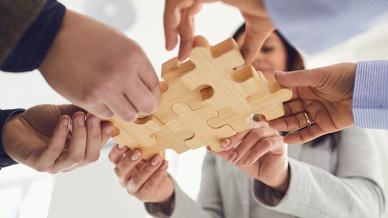 Coworkers putting puzzle pieces together