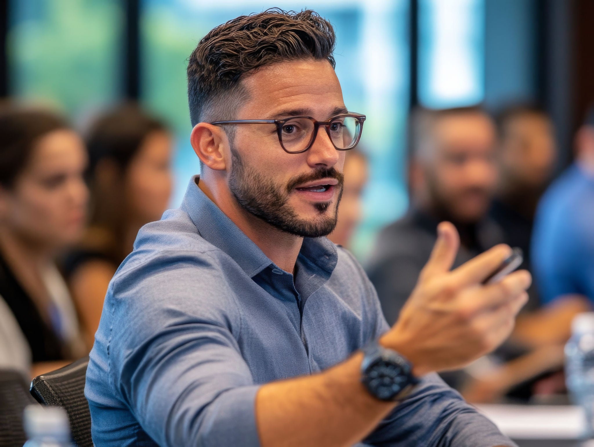 You man with beard and glasses gesturing with his hand.