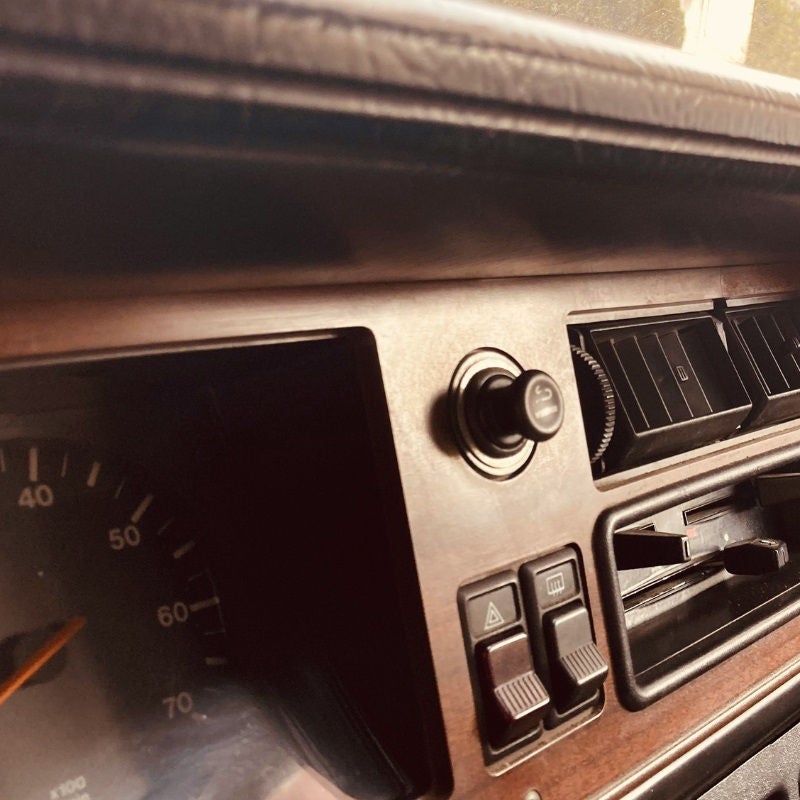 The dashboard of a vintage 1980s car. 