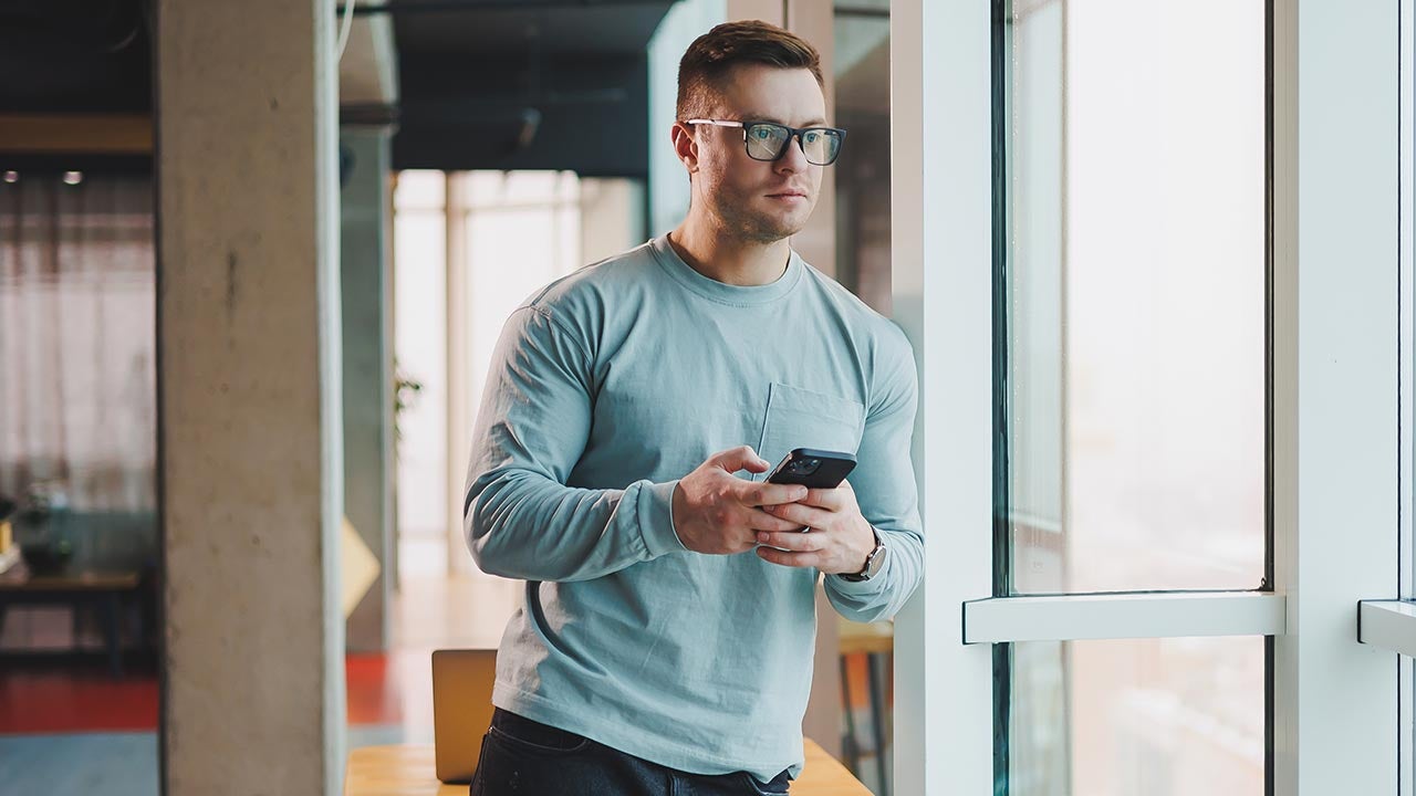 Man looking out window with a concern.