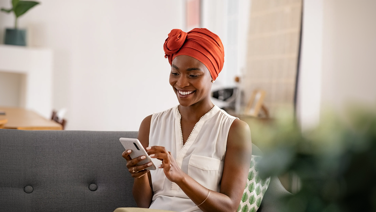 A woman sitting on a couch using a cell