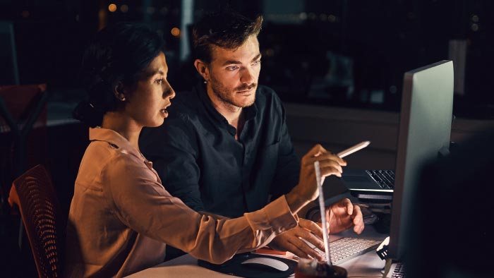 Two collegues working in dark office.