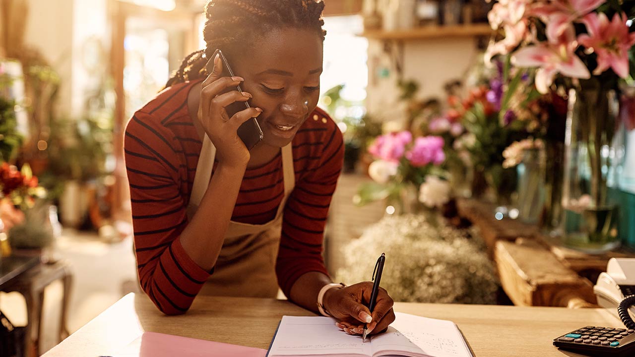 Florist taking order over the phone at flower shop.