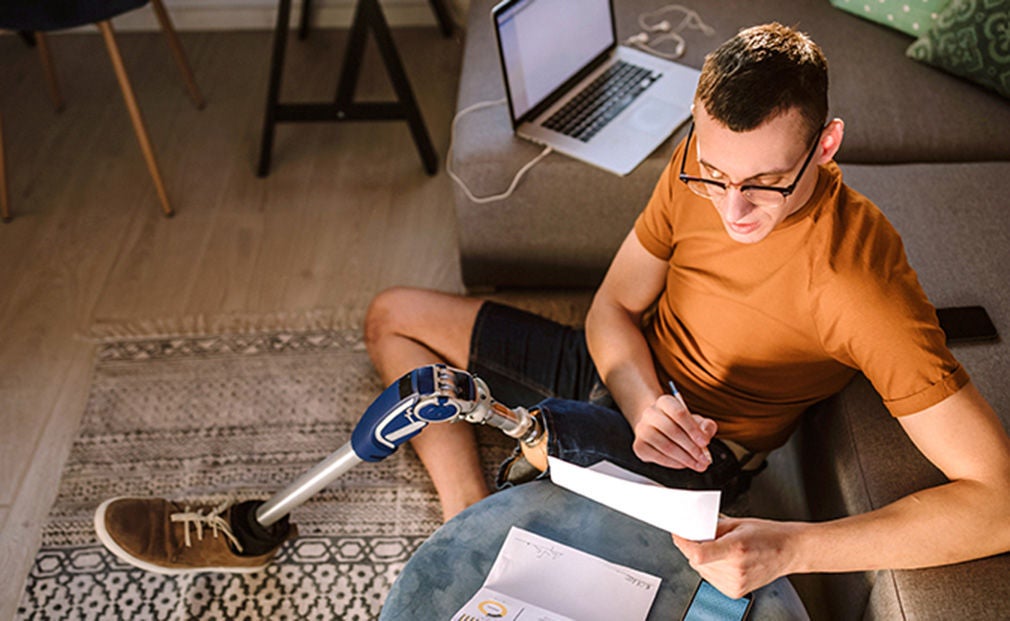 Man with prosthetic leg reviewing bank statements