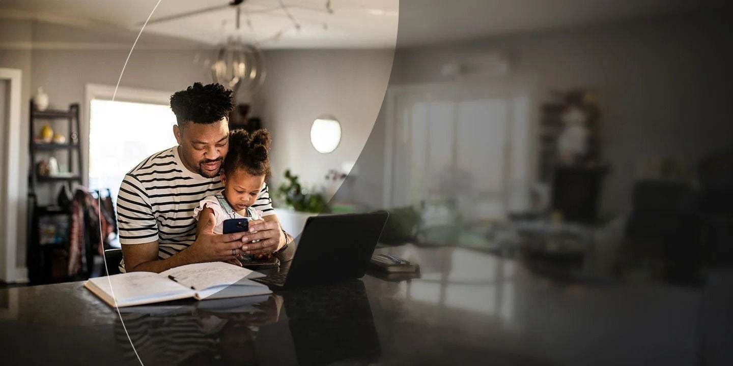 גבר עם ילד מביטים בטלפון במטבח.