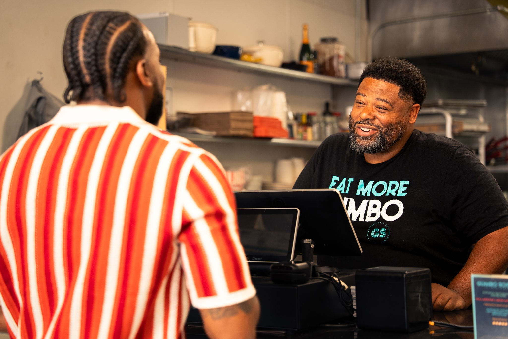 Man at restaurant cash register smiling
