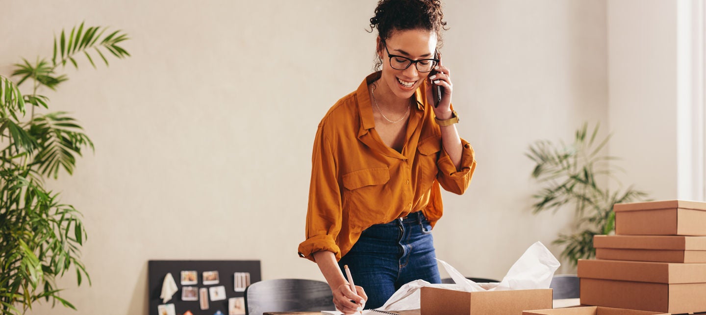 Woman on the phone doing work in her home office