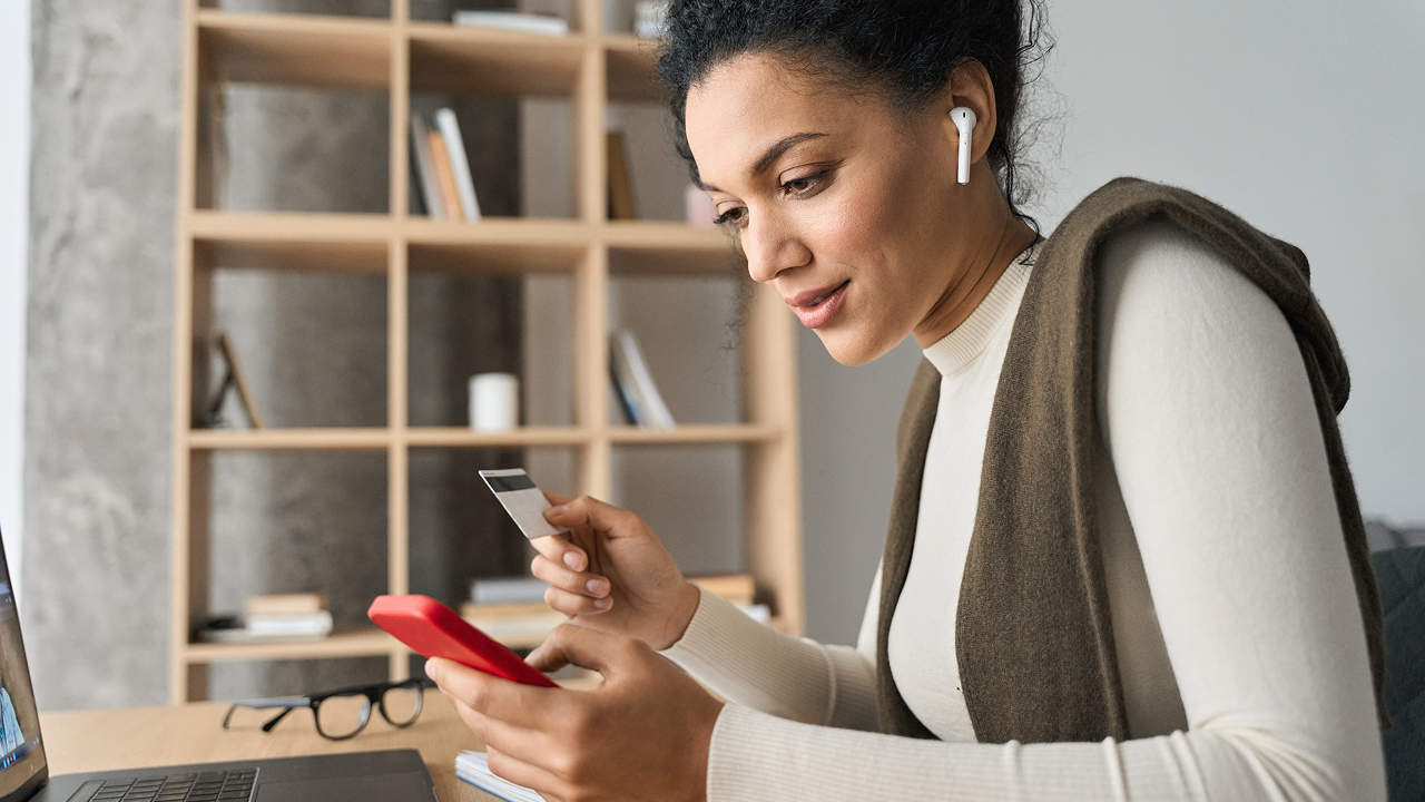 Woman sitting at a desk using a cell phone