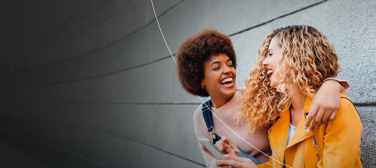 Two smiling people enjoying the benefits of being a Mastercard cardholder.