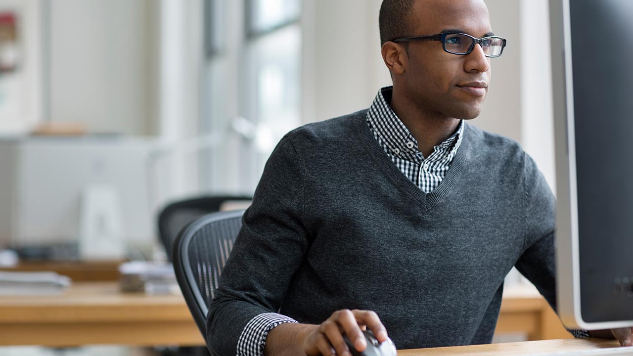 Determined man focused on desktop computer.