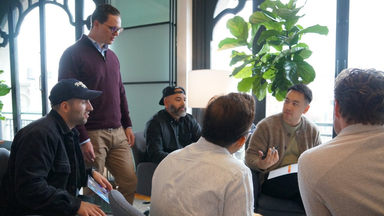 A man speaks to others in an office. 