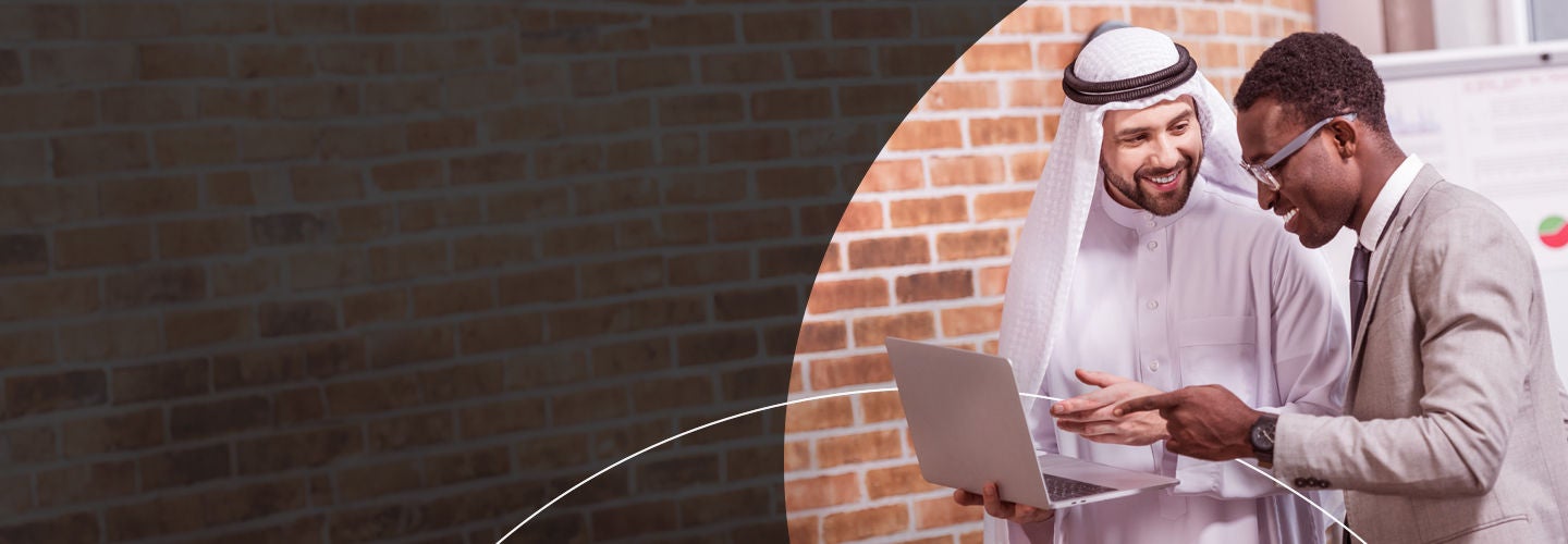 Two men discussing something on a laptop