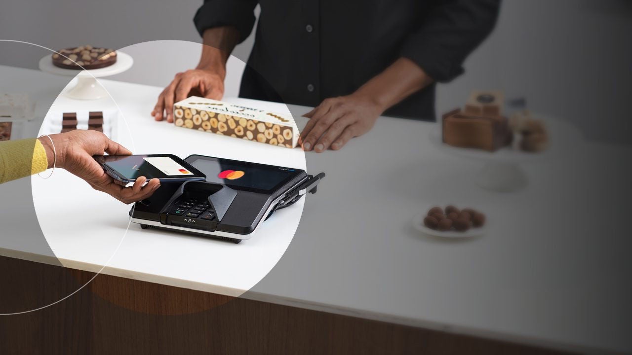 العميل يقوم بإجراء دفعة Mastercard بدون تلامس باستخدام الهاتف.