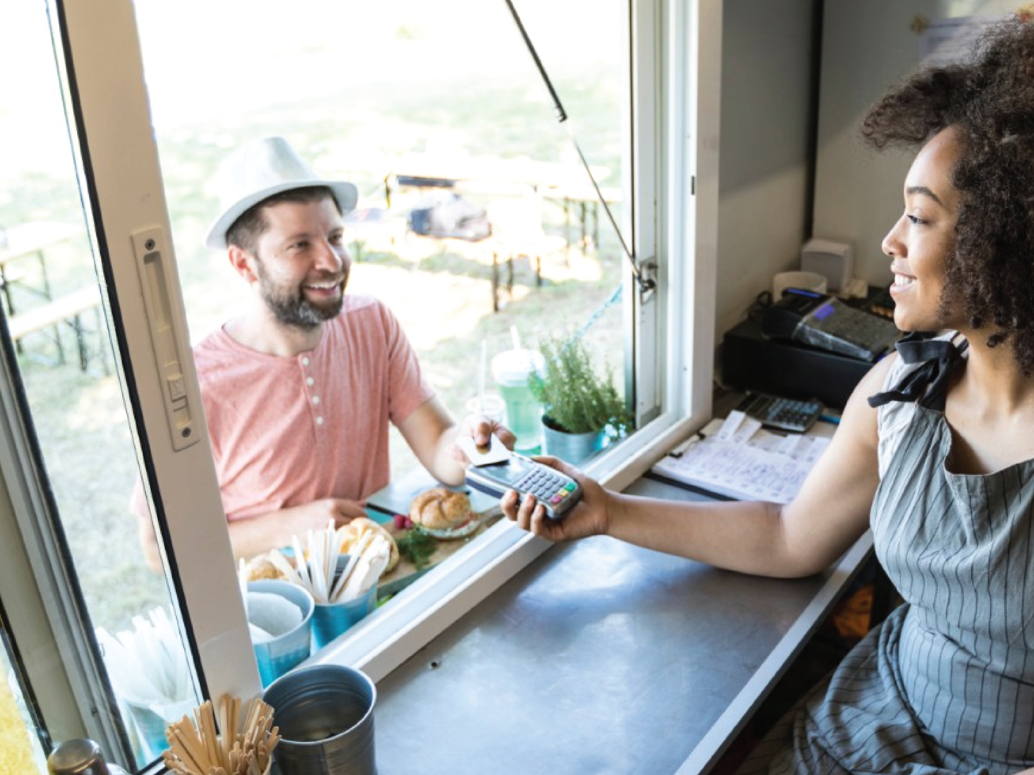 People completing a transaction through a take out window
