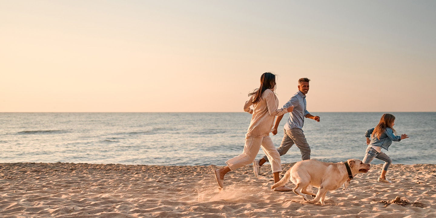 Family playing at the beach during sunset