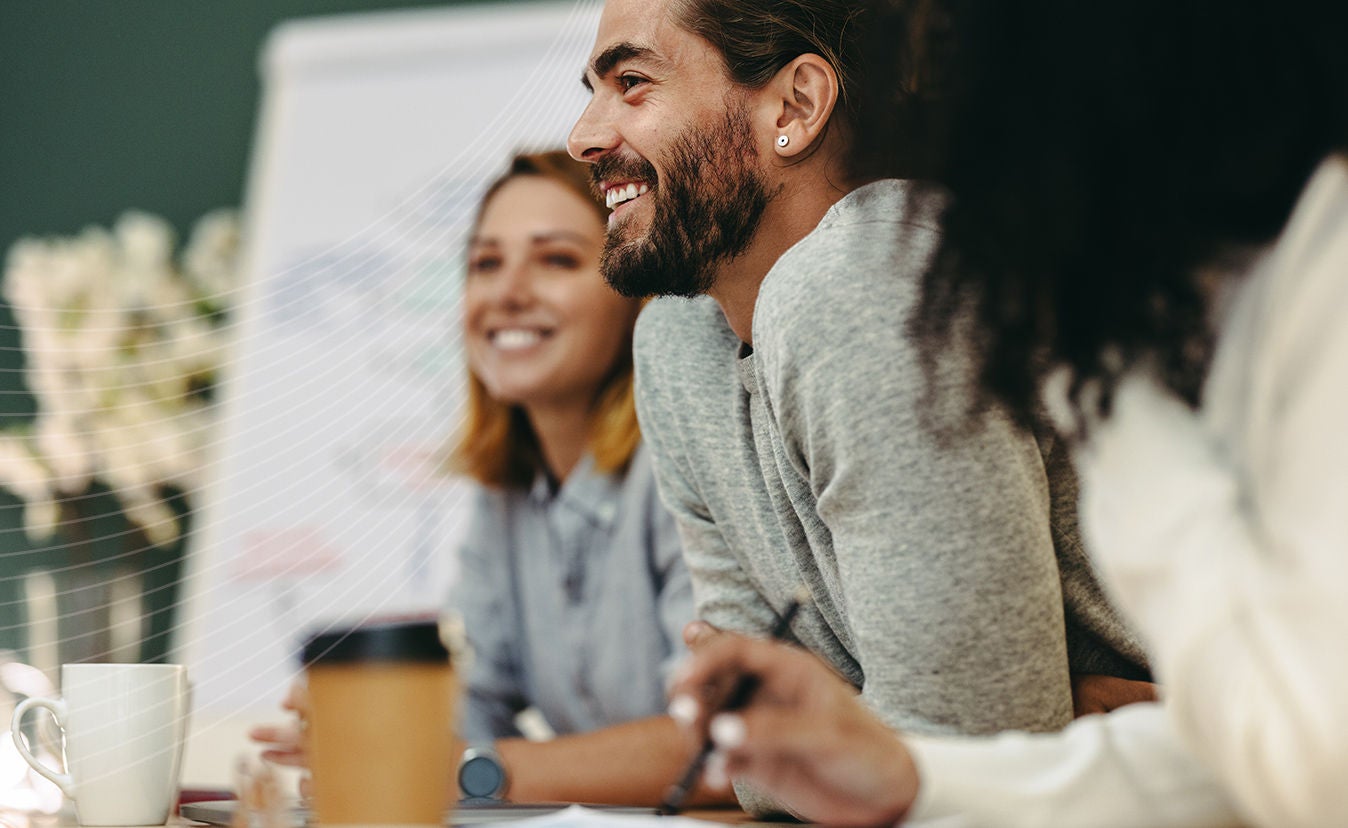 Pessoas sorrindo em uma sala de reuniões