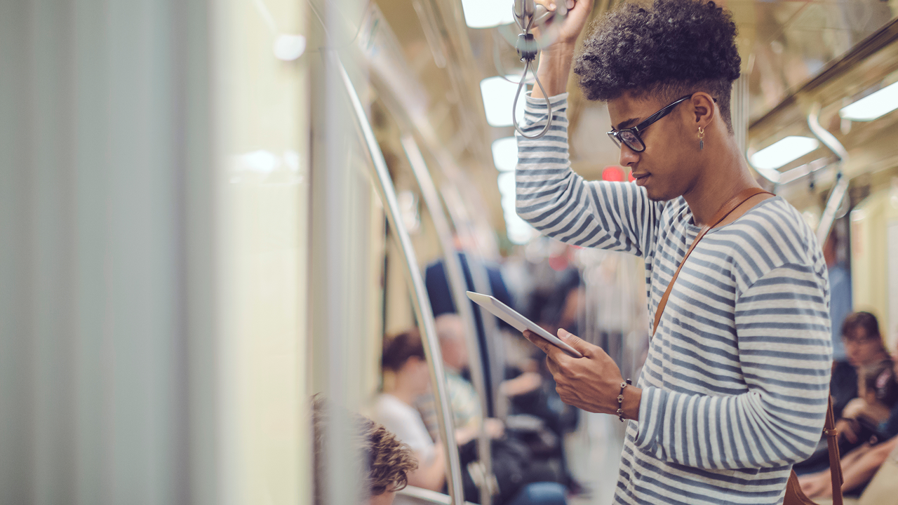 Man on tube on his tablet