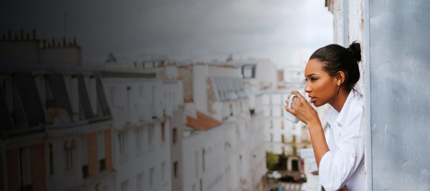 woman drinks coffee on a balcony