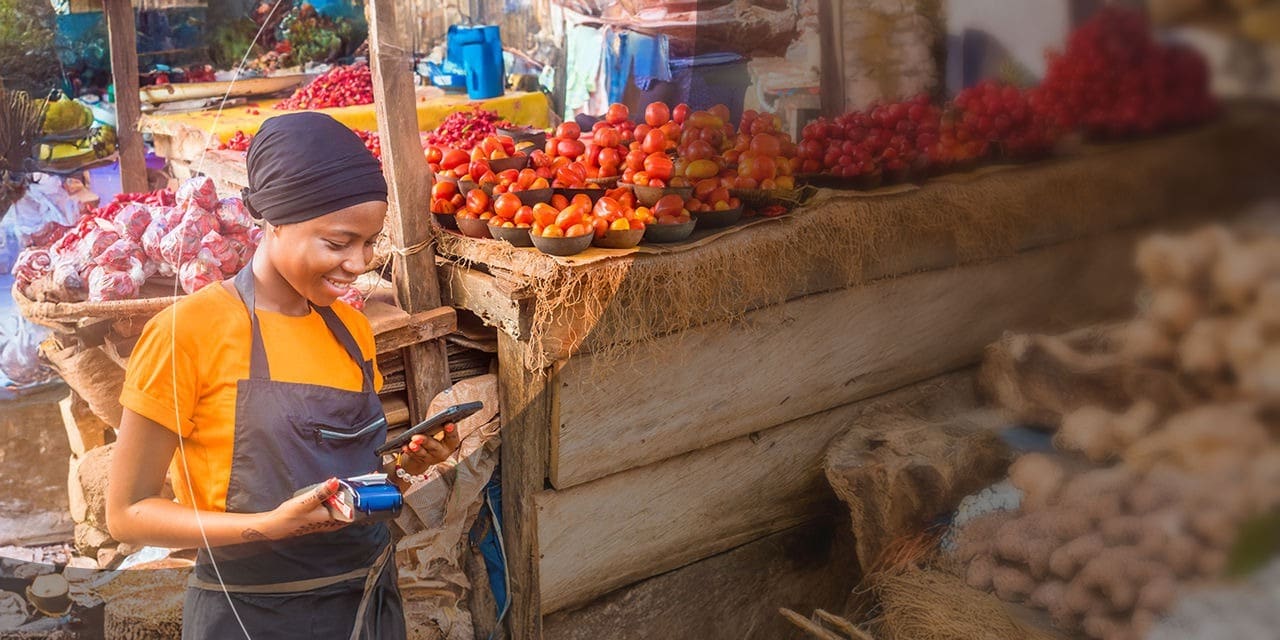 امرأة تعالج الدفع الرقمي في كشك السوق