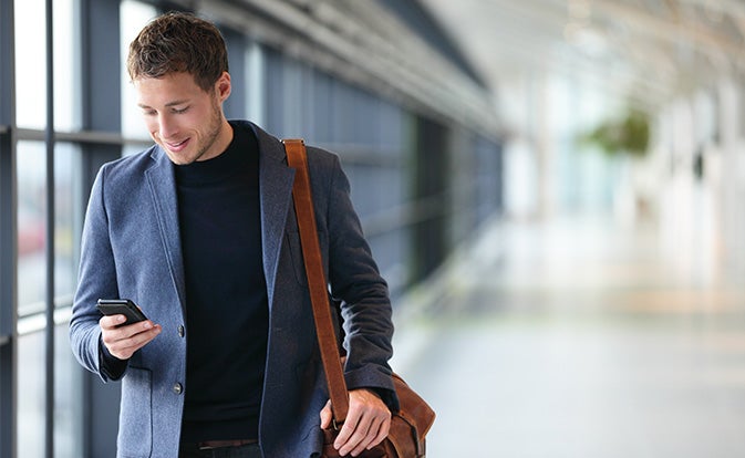 young businessman in an airport terminal engaged with his smartphone.