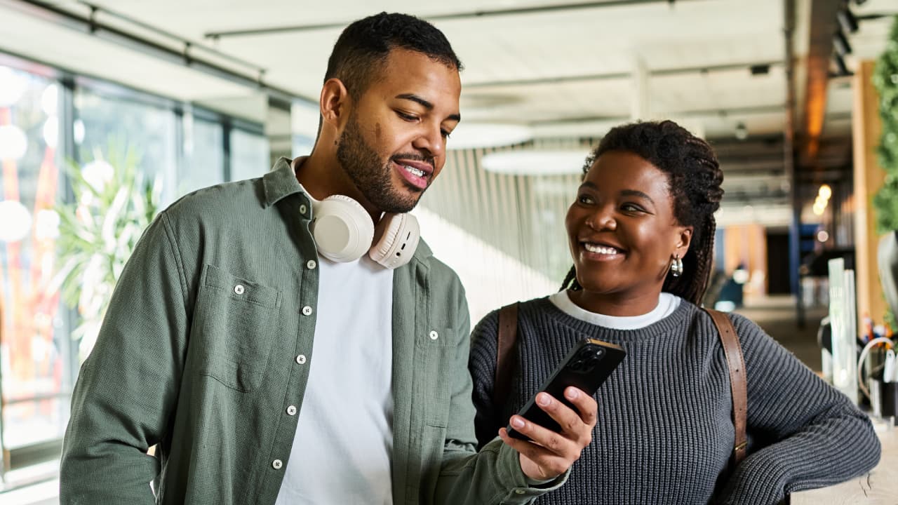 man showing smartphone to a woman