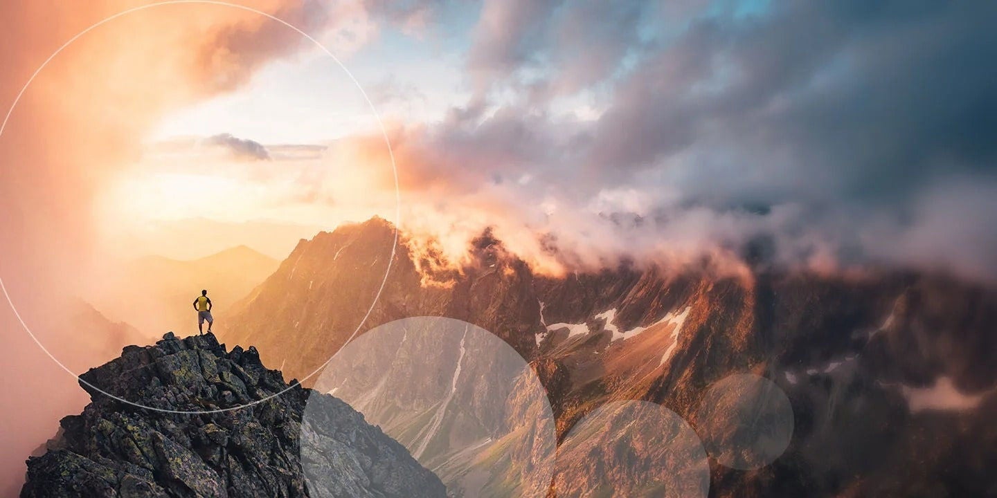 אדם עומד בניצחון על פסגת הר, מוקף בעיגול קלוש, ומציג את הישגיו בטבע.