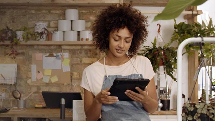A flower shop worker using a tablet.