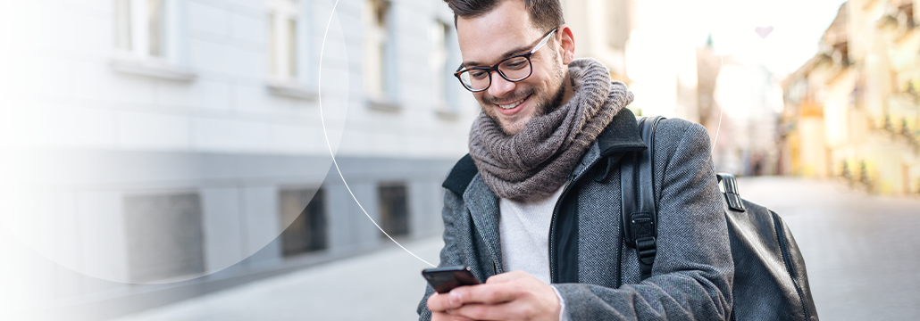 Man outside in winter on phone looking at open banking