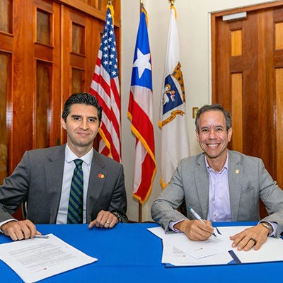 Two men signing an agreement at office