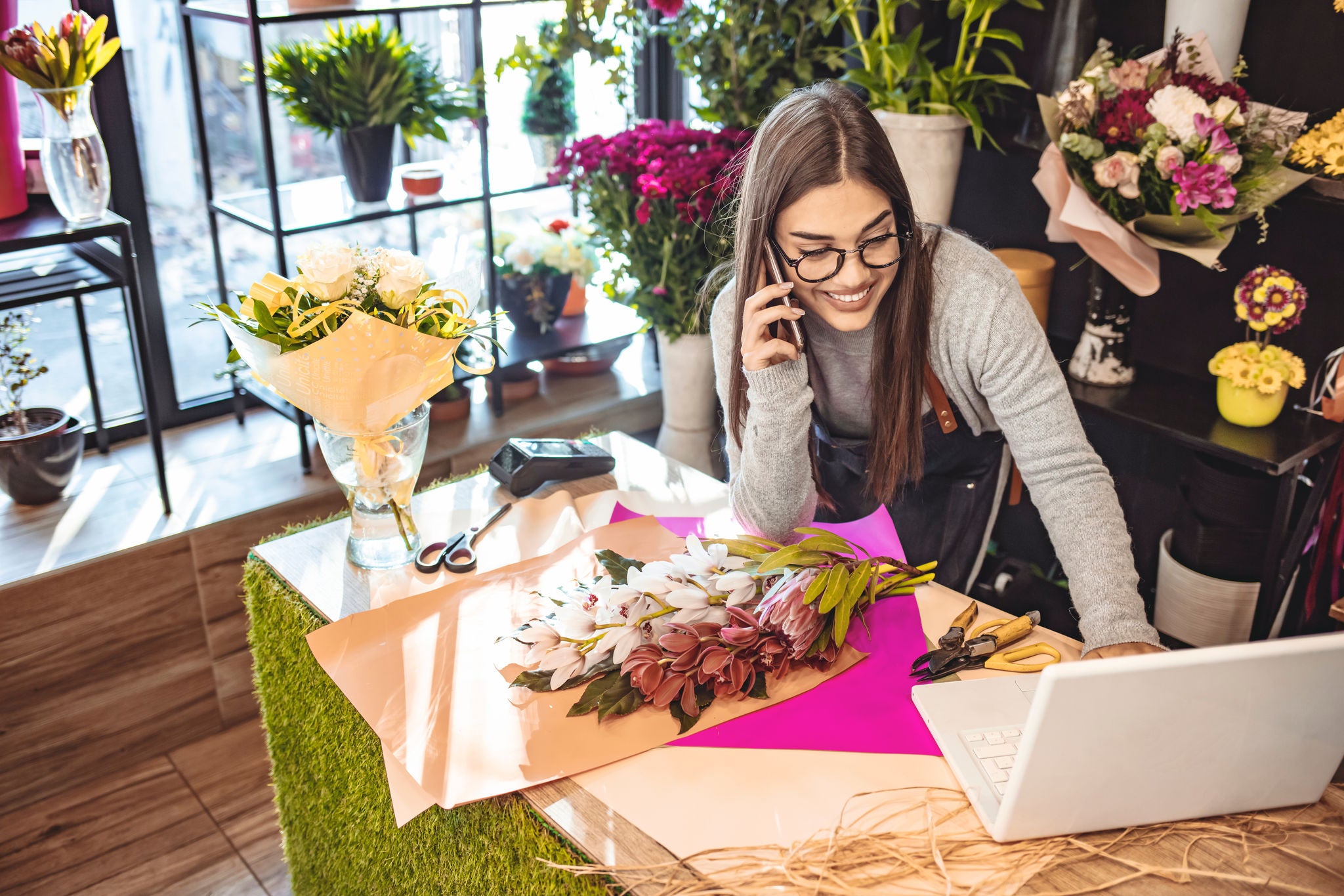 Kolege pregledaju laptop u trgovini.