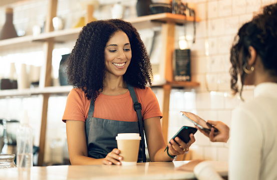 Tap phone payment bewtween two women for coffee