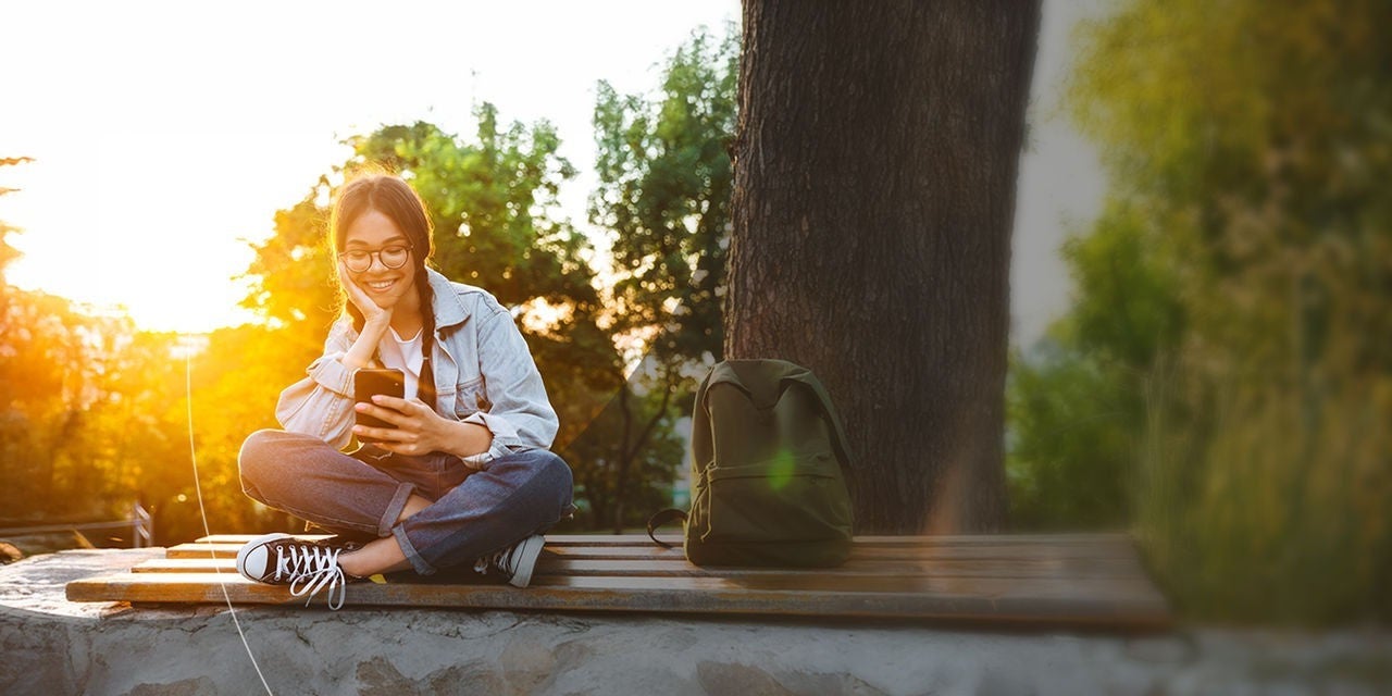סטודנטית צעירה ומאושרת, מרכיבה משקפיים.