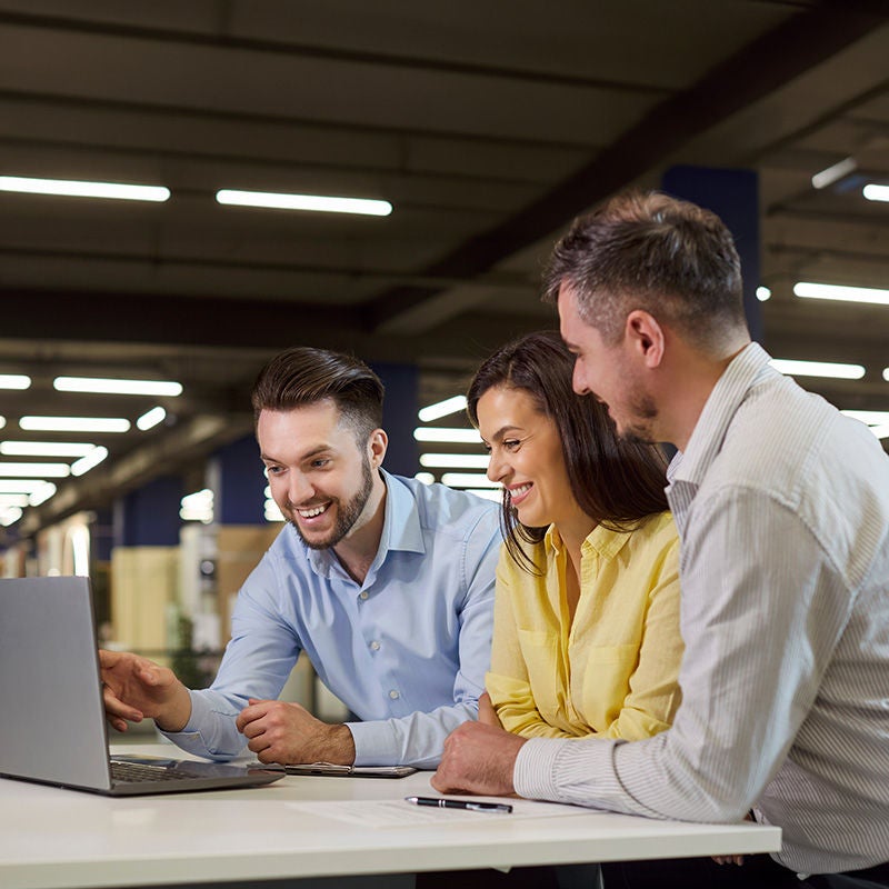 People gathered around a laptop on a table