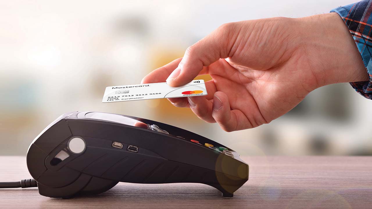 hand tapping card on payment terminal