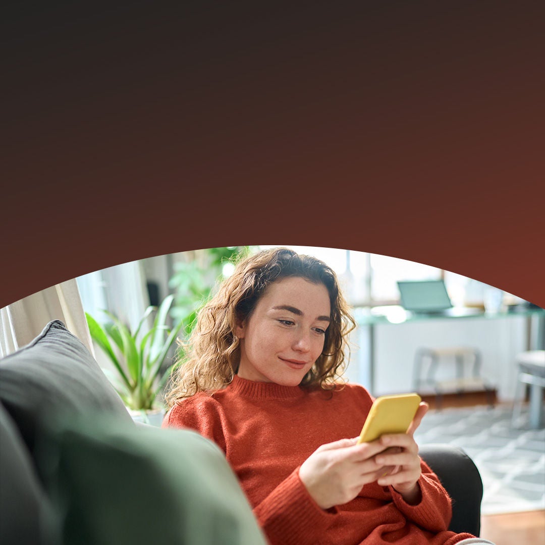 Relaxed woman sitting on couch using phone.
