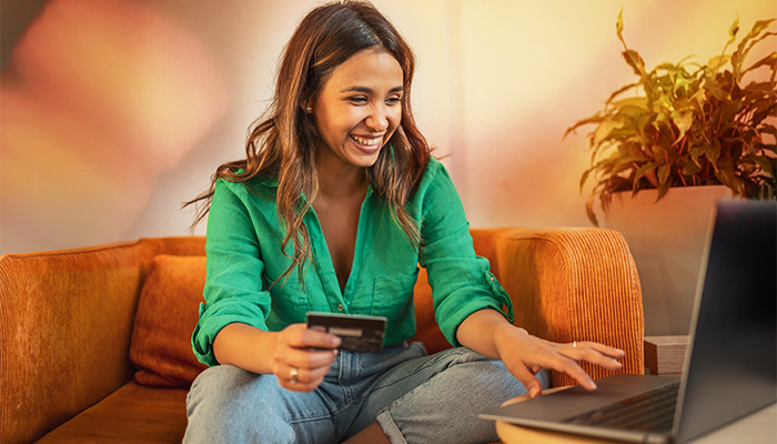 Mujer en su computadora ingresando el número de su tarjeta