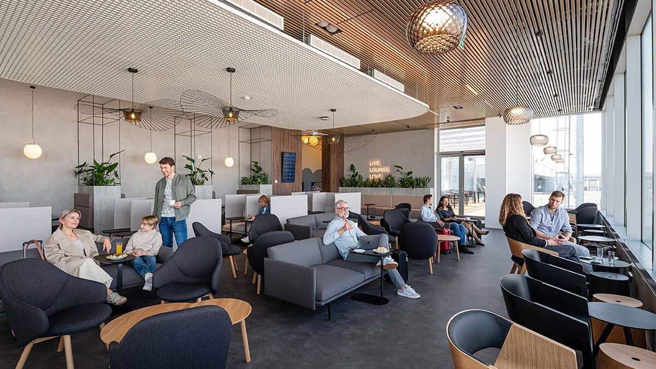 ľudia relaxujúci v letiskovej hale