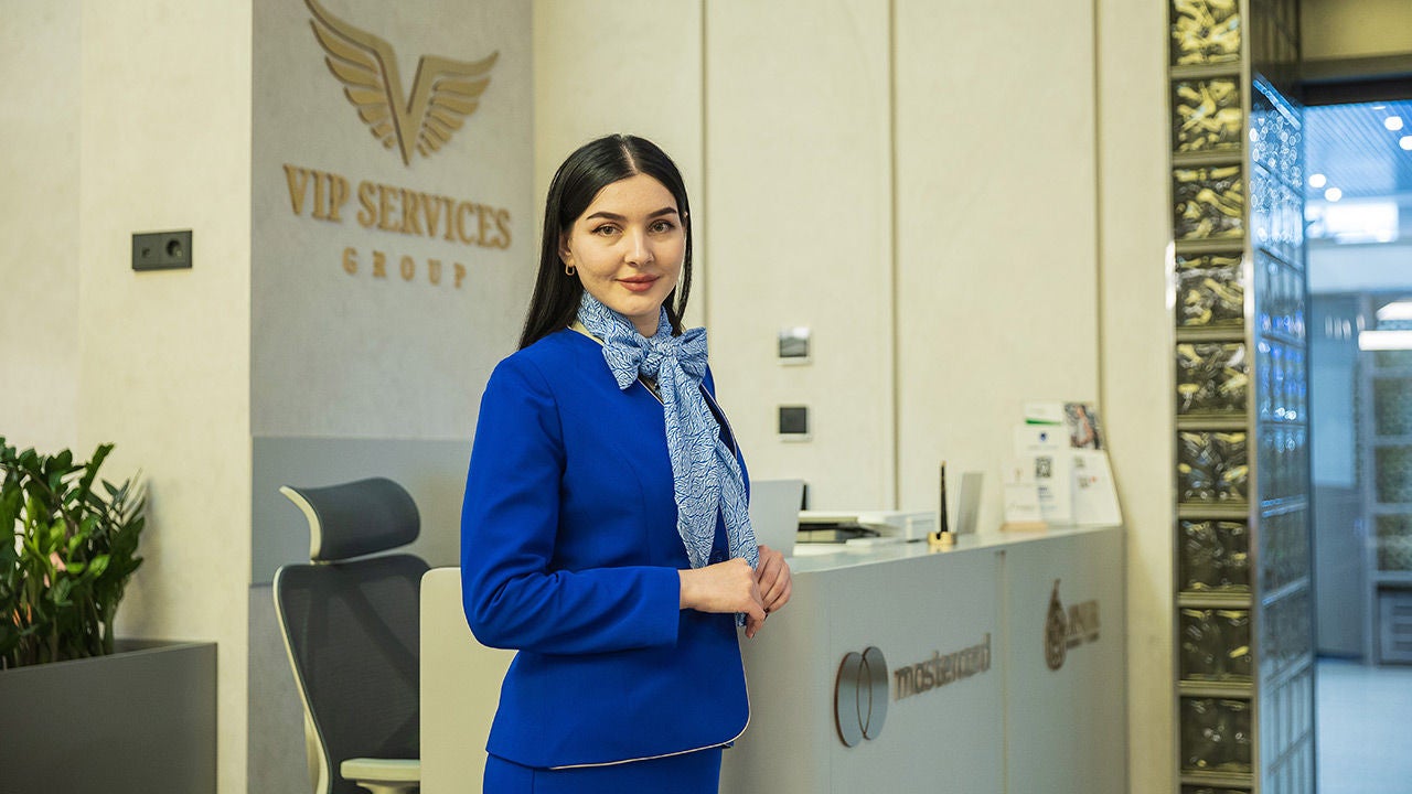 Девушка стоит около бизнес-зала “Anjir”